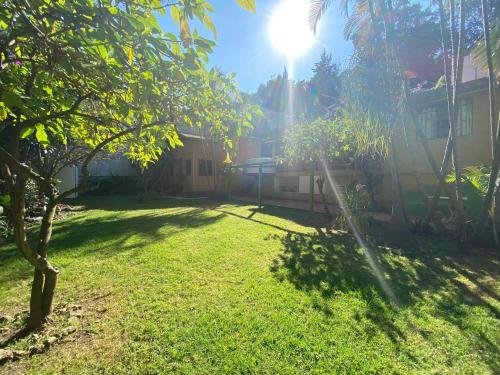 a yard with a house with the sun shining at El Apapacho in Cuernavaca