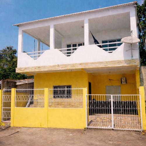 a yellow and white house with a yellow fence at Ybirá - Casa Inteira no Centro de Alter do Chão in Alter do Chao