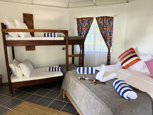 a room with two bunk beds and a window at Coral Quays Resort in Luganville