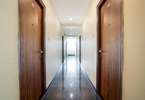 a hallway with two wooden doors and a long corridor at Super Hotel O Gokul Grand Near SR Nagar Police Station in Hyderabad