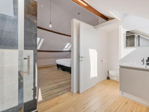 a bathroom with a sink and a bed in a room at De Loft in Veurne