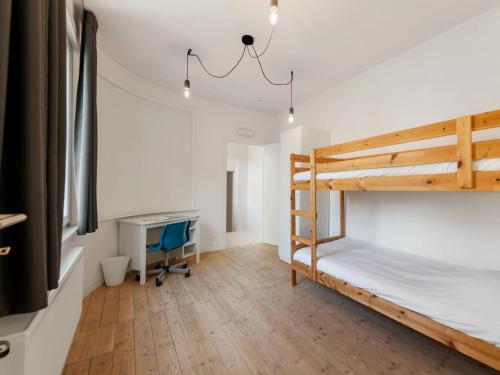 a bedroom with two bunk beds and a desk at De Loft in Veurne