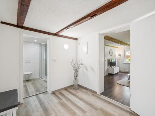 an open living room with white walls and a vase of flowers at Modern apartments harz I in Elbingerode