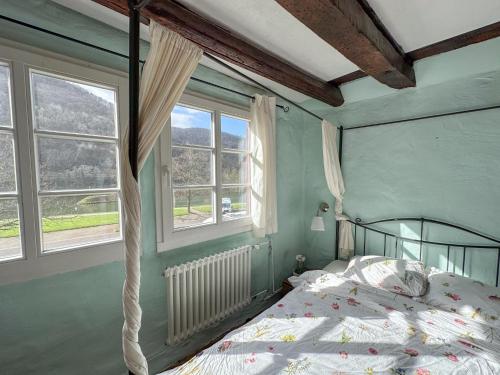 a bedroom with a bed and two windows at Zum Anker in Bernkastel-Kues