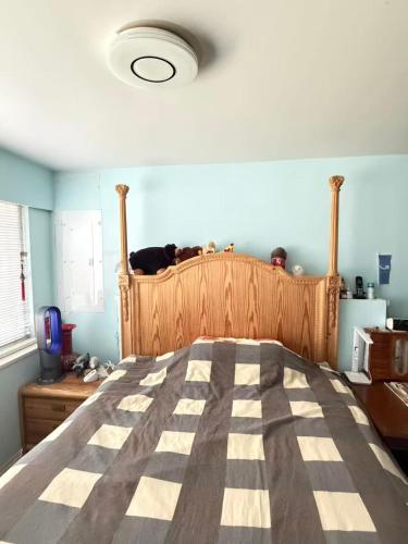 a cat sitting on top of a bed in a bedroom at Cozy EnSuite No Pets Allowed in Burnaby