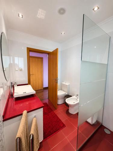 a bathroom with a toilet and a sink and a mirror at Villa Livramento in Ponta do Sol