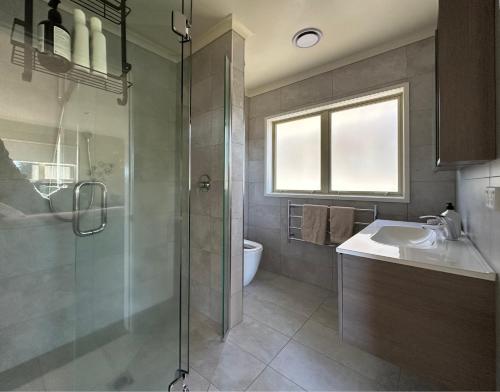 a bathroom with a shower and a sink and a toilet at Studio Haven on Fort in Cambridge