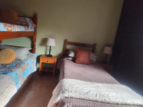a bedroom with two beds and a night stand with lamps at Las palmas in Costa Azul