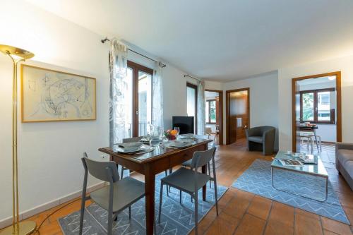 a living room with a table and chairs and a couch at Casa Chiara Muralto with Balcony & Wi‑Fi - Happy Rentals in Locarno