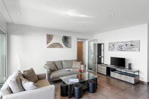 a living room with a couch and a table at Art Apartment Locarno - Balcony and Parking - Happy Rentals in Locarno