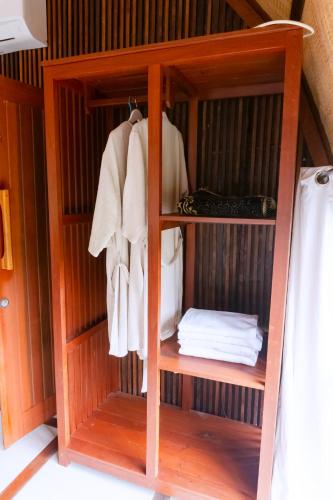 a wooden closet with white towels in it at Saung Komando Ciwidey in Winducina