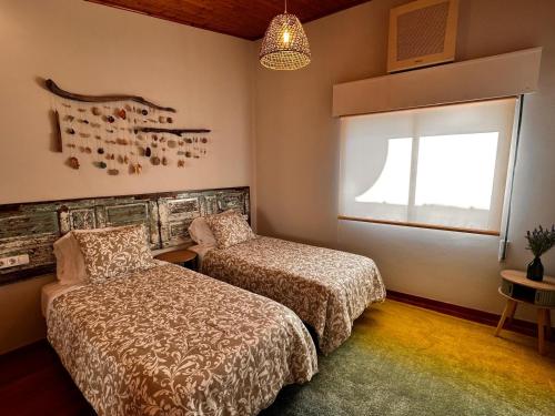 a bedroom with two beds and a window at Rincón Atlántico ático deluxe in Moaña