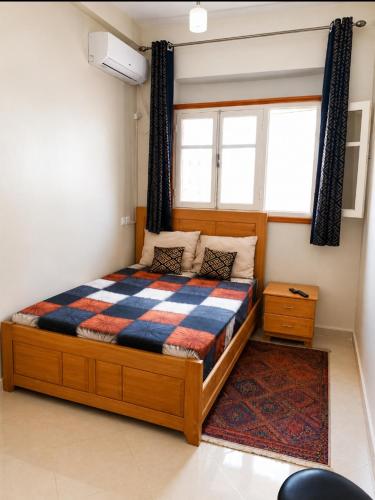 a bedroom with a bed with a checkered blanket at Maison d'hôte Najah 1 in Khenifra