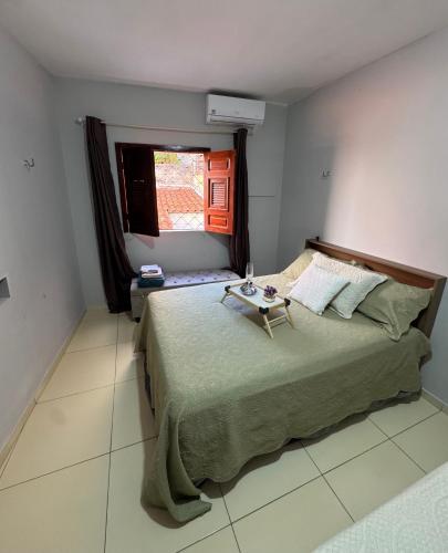 a bedroom with a bed with a table on it at Lindo apartamento coração de Picos in Picos