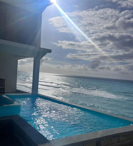 a swimming pool with the ocean in the background at Privanza Hotels in Santa Cruz de Barahona