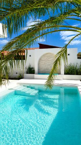 a blue swimming pool in front of a house at Villa Atlantica - Preá in Prea
