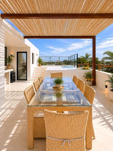 a patio with a glass table and chairs at Villa Atlantica - Preá in Prea