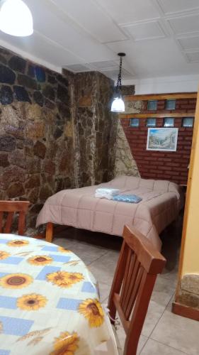 a bedroom with a bed and a table and chairs at Cerros Azules in Trapiche