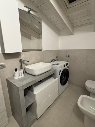 a bathroom with a sink and a washing machine at Felicita Cascata Terrace with Lake View in Lecco