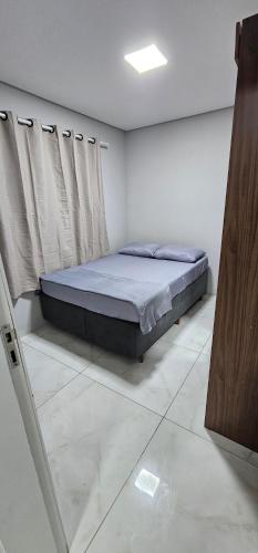 a bedroom with a bed in the corner of a room at RG Kitnet05 in Curitiba