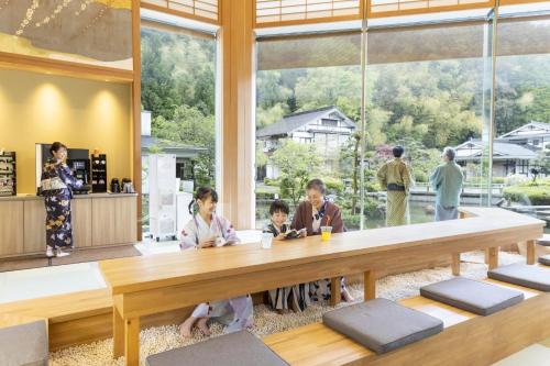 a group of people sitting at a table in a room at Ooedo Onsen Monogatari Premium Saiki Bekkan in Misasa