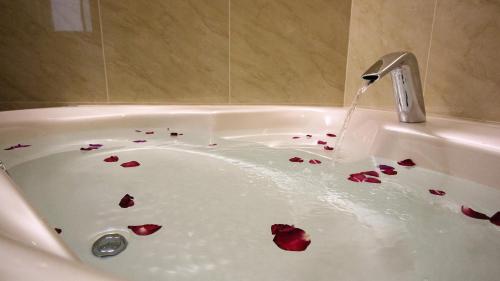 a bath tub filled with bleeding red roses at Gold Sand Hotel in Hsinchu City