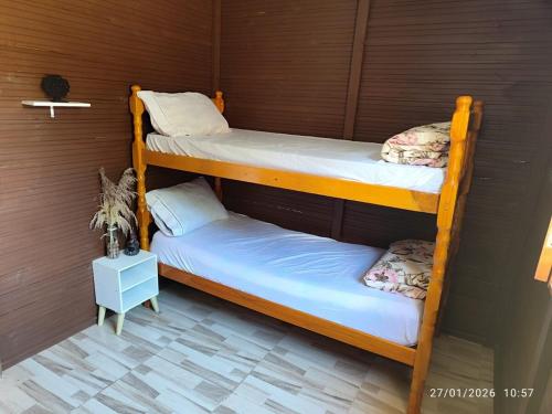 two bunk beds in a room with a wall at Chacara Pôr do Sol Capivari in Campina Grande do Sul