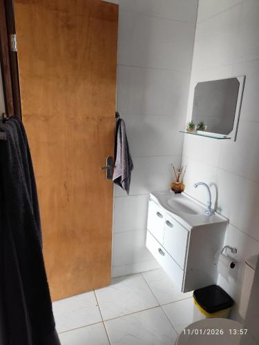 a bathroom with a shower and a sink and a door at Chacara Pôr do Sol Capivari in Campina Grande do Sul