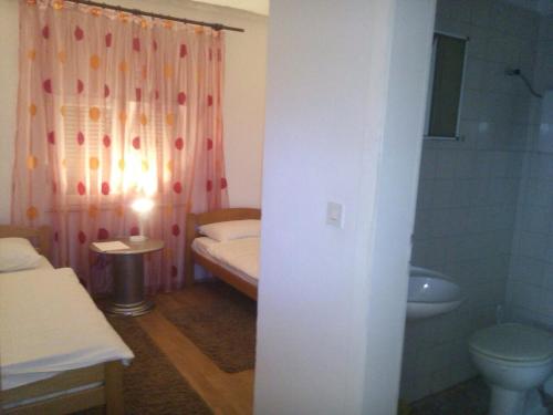 a bathroom with a bed and a toilet and a sink at Guest House Star in Međugorje