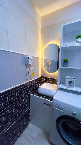a bathroom with a washing machine and a mirror at Perle de Tamaris Appartement Moderne, Bien Équipé, Piscine pour Enfants Parking in Casablanca