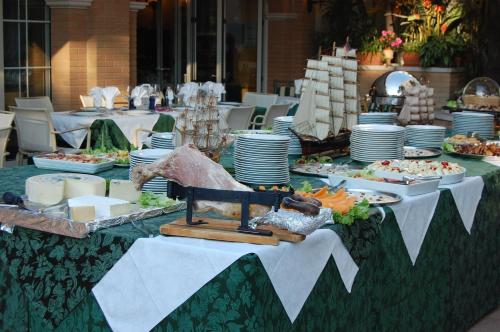 a long table with plates and food on it at Park Hotel Pineta Boutique Hotel in Caorle