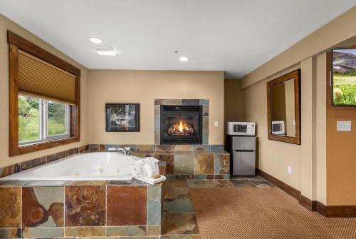 a large bathroom with a tub and a fireplace at Duck Inn Lodge in Whitefish