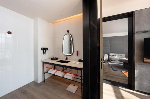 a bathroom with a sink and a mirror at SSAW Yintai Boutique Hotel Qiandao Lake in Chun'an