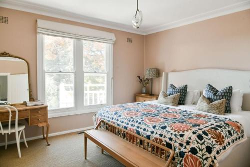 a bedroom with a bed and a desk and a window at Treehouse Southern Highlands in Moss Vale