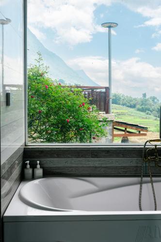a bath tub in a bathroom with a window at Larosa Homestay Sapa in Sa Pả