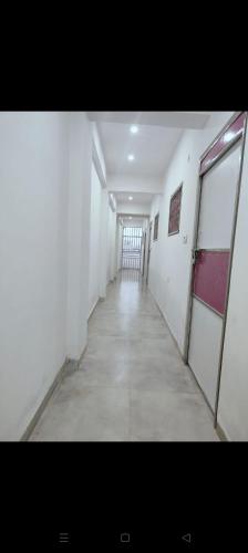 a hallway in a building with white walls and a hallwayngth at Agrasen Homestay in Prayagraj