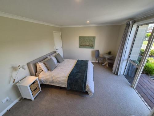 a bedroom with a large bed and a balcony at Monarch Park Studio in Cambridge