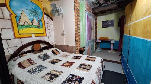 a bedroom with a bed with a quilt on it at Hotel Atenas in Jericó