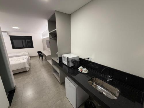 a bathroom with a sink and a bed in a room at Hotel Morada do Sol in Chavantina