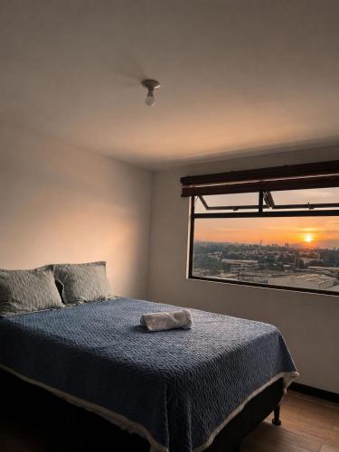 a bedroom with a bed and a large window at Escápate- Roomgt in Boca Monte