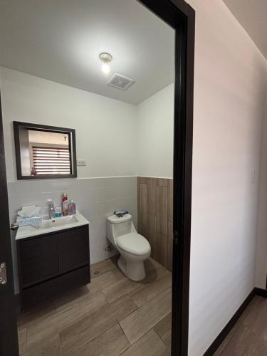 a bathroom with a toilet and a sink at Escápate- Roomgt in Boca Monte
