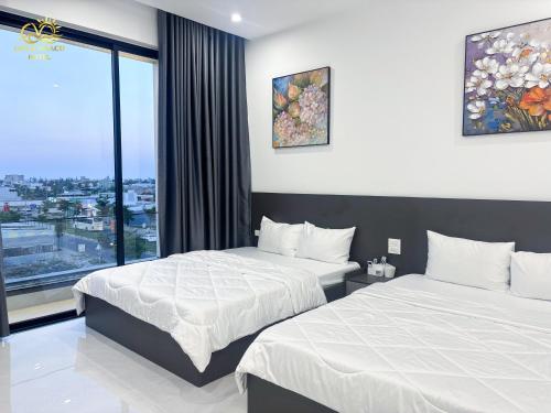 a hotel room with two beds and a window at Hotel Gold Beach in Phương Phi