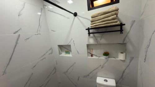 a bathroom with white marble walls and a towel rack at Beit Shalom habitaciones con clima in Orizaba