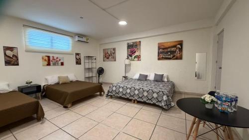 a living room with two beds and a table at Beit Shalom habitaciones con clima in Orizaba