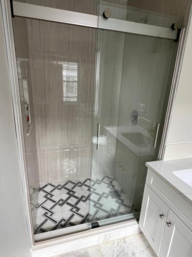 a shower with a glass door in a bathroom at Airport room with free parking in Boston