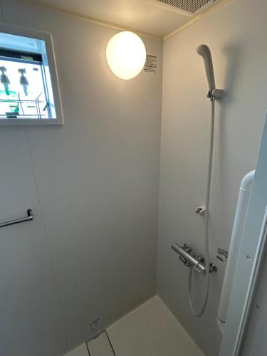 a bathroom with a shower with a light on the wall at 竹葉庵 in Nagaokakyo