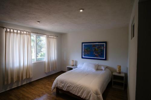 a bedroom with a large bed and a window at Casa Los Agapandos in Valle de Bravo