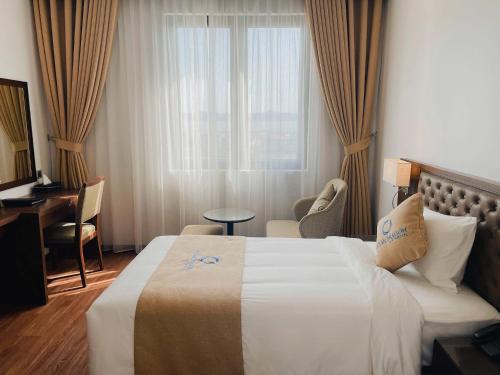 a hotel room with a bed and a desk and a window at ocean dragon in Ha Long