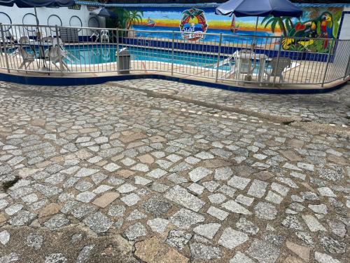 a fence next to a swimming pool with an umbrella at Guiapa en melgar in Melgar