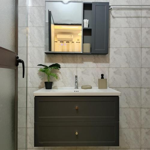 a bathroom with a sink and a mirror at Le Cocon coloré Work and Chill KÉgué in Avéimé